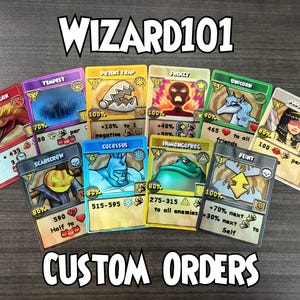 Peut inclure: Une collection de cartes de jeu Wizard101 custom orders représentant divers personnages et sorts comme Fire Dragon, Tempest et Colossus. Chaque carte affiche des statistiques de puissance, des icônes et du texte sur une surface sombre.