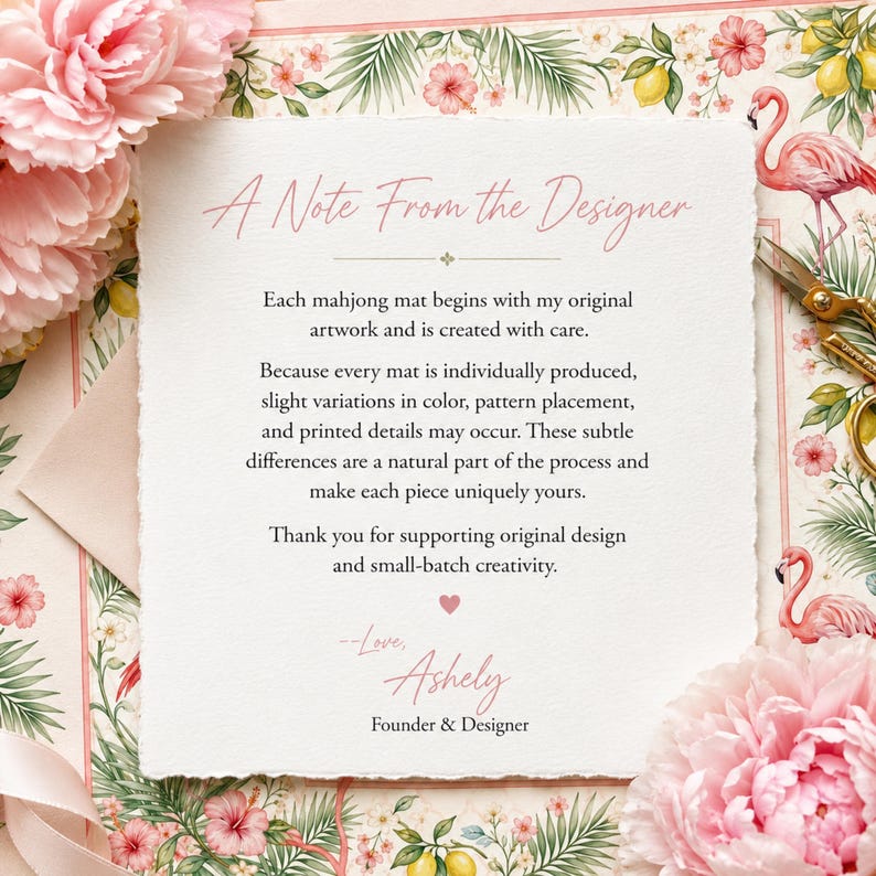 May include: A square card with deckled edges featuring the text A Note From The Designer, explaining that each mahjong mat is individually produced with original artwork. The card is decorated with pink peonies, green palm leaves, and pink flamingos.