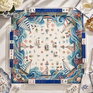 Puede incluir: Un juego de mesa de mahjong cuadrado con temática náutica, que presenta ilustraciones de veleros, conchas, corales y cuerdas sobre un fondo crema. El tablero está rodeado por cuatro soportes de acrílico transparente con fichas azules y blancas.