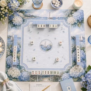 Puede incluir: Una alfombrilla de mahjong rectangular con un patr&oacute;n floral de hortensias en azul claro y blanco y una ilustraci&oacute;n central de un velero. Incluye cuatro soportes para fichas, un juego de fichas de mahjong con caracteres chinos y una tarjeta.