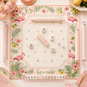 May include: A square mahjong game mat featuring a cream-colored center with a delicate lattice pattern, surrounded by a border of pink flamingos, hibiscus flowers, and lemons. Includes four clear tile racks, scattered mahjong tiles, and two dice.