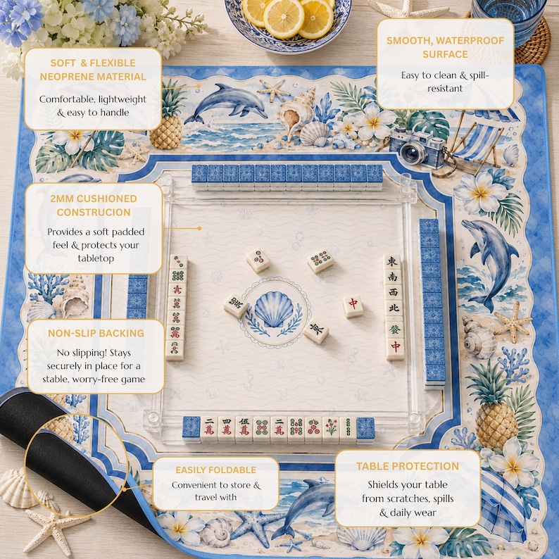 Peut inclure: Un tapis de mah-jong carr&eacute; en n&eacute;opr&egrave;ne avec une bordure sur le th&egrave;me de la plage orn&eacute;e de dauphins, d'ananas, de coquillages et de fleurs tropicales. Le centre pr&eacute;sente un fond cr&egrave;me clair avec un coquillage bleu et des tuiles de jeu.