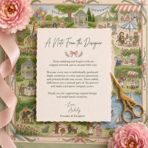 May include: A rectangular card with deckled edges featuring the text A Note From The Designer, placed over a colorful illustration of animals in a park. A gold-colored bird-shaped pair of scissors and pink flowers are positioned on the card.