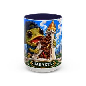 Puede incluir: Una taza de cerámica con interior azul oscuro que presenta una ilustración colorida de una rana verde con gorra de béisbol negra, comiendo un trozo grande de comida de un monumento de piedra. La base incluye una pancarta verde con el texto JAKARTA.