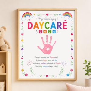 May include: A framed poster titled My First Day of DAYCARE 2026 featuring a pink handprint in the center. The design includes colorful rainbows, hearts, flowers, and text that reads: Today is my very first daycare day! A place to laugh, learn, and play.