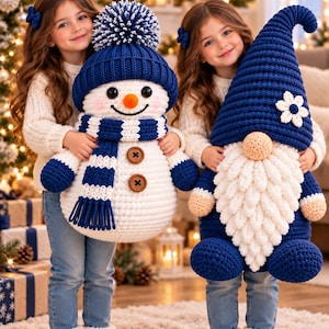 May include: A large crocheted snowman plush with a blue pom-pom hat, striped scarf, and brown buttons, alongside a large crocheted gnome plush with a tall blue hat, a white flower accent, and a long textured white beard.