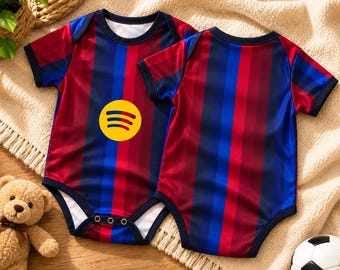 Könnte beinhalten: Zwei kurzärmelige Baby-Bodys mit vertikalen Streifen in Dunkelrot, Marineblau und Hellblau. Ein Body zeigt ein gelbes, kreisförmiges Spotify-Logo auf der Brust. Beide Kleidungsstücke haben marineblaue Abschlüsse an Hals und Ärmeln.