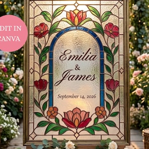 Op de afbeelding: Een rechthoekig glas-in-lood bord in een gouden lijst met een bloemenrand van rode en oranje bloemen en groene bladeren. In het midden staat de tekst "Emilia & James" en "September 14, 2026" in een donker lettertype. Een roze cirkel met "EDIT IN CANVA" is zichtbaar.