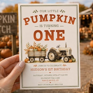 May include: A rectangular birthday invitation card featuring the text "OUR LITTLE PUMPKIN IS TURNING ONE" in orange and brown. The design includes an illustration of a tractor pulling a wagon filled with pumpkins, with event details below.