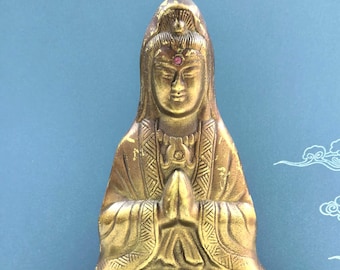 Statua di Guan Yin seduta con mani giunte, base a loto e rilievo della veste.