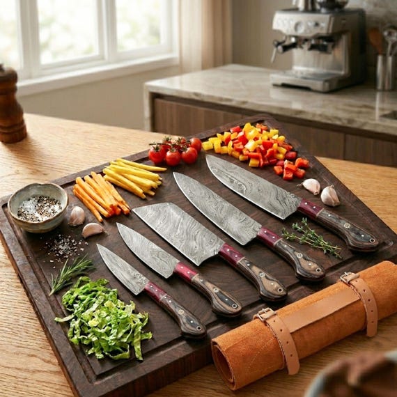 A 5-piece Damascus steel chef knife set with hand-forged layered blade patterns and wooden handles — functional kitchen art that looks as good on display as it does in use.