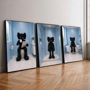 Peut inclure: Un ensemble de trois cadres muraux représentant un personnage KAWS noir brillant dans une salle de bain bleu clair. La première affiche montre la figurine sur des toilettes, la deuxième sous une douche et la troisième sur une baignoire blanche.