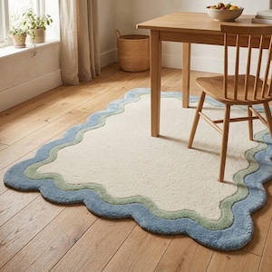 Scalloped wavy border rug placed under a wooden table in a dining area on hardwood flooring