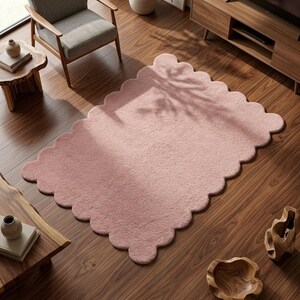 Scalloped border pink carpet featuring a cloud-inspired design for modern nursery and bedroom decor. Its plush-looking surface and rounded edges create a soft visual effect that complements cozy interiors. Suitable for children's rooms, reading nooks, living rooms, and relaxation areas, this decorative rug pairs well with pastel cushions, wooden furniture, cream bedding, and minimalist accessories. The organic shape brings personality to Scandinavian and contemporary spaces.