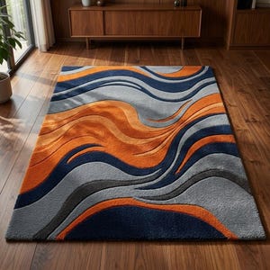 May include: A rectangular area rug featuring a textured, carved-look design with flowing, wavy bands in vibrant orange, deep navy blue, and various shades of light and dark gray. The rug has a thick, plush pile with distinct, sculpted contours.
