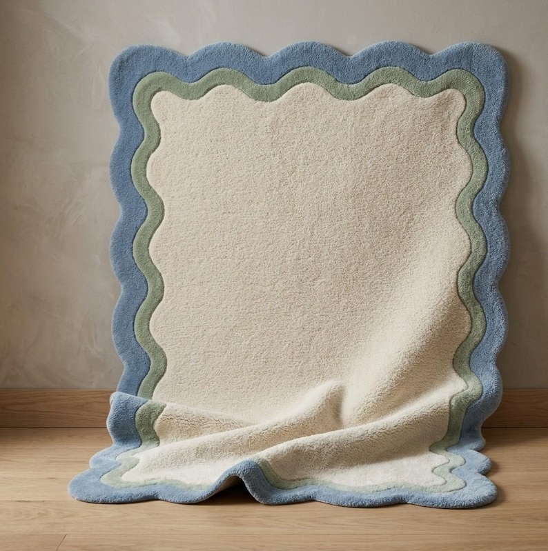Close-up of scalloped rug corner showing blue wavy border detail against a white curtain background