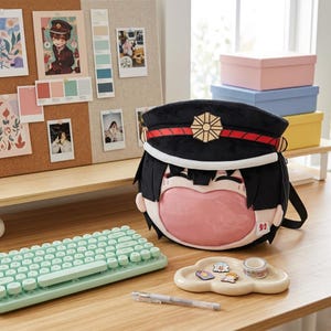 May include: A plush backpack shaped like an anime character head wearing a black military-style cap with a gold emblem and red trim. The character has black hair and a large, clear, pink-tinted circular window on the front with a small white tag.