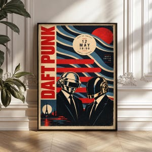 May include: A rectangular poster featuring the text DAFT PUNK in large red letters. The graphic shows two figures in suits and metallic helmets against a background of blue wavy lines and a red sun. Text includes 12 MAY 18:00 PARIS FRANCE.