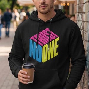 May include: A black hooded sweatshirt featuring a graphic of a three-dimensional cube with the text TRUST NO ONE printed on its sides. The top of the cube is pink, the left side is blue, and the right side is yellow. The hoodie has a front pocket.