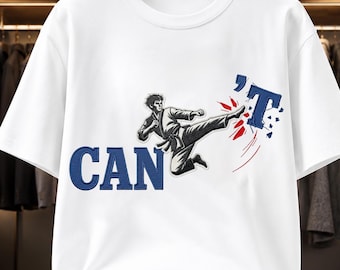 May include: A white short-sleeved t-shirt featuring a graphic of a martial artist in a black gi performing a side kick. The graphic includes the blue text CAN and T, with the martial artist's foot breaking the letter T into red fragments.