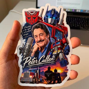 May include: A die-cut sticker featuring a portrait of Peter Cullen, a microphone, and Optimus Prime. Text reads: Freedom is the right of all sentient beings, Peter Cullen, and Legendary Voice. Includes a red and blue truck and a sunset landscape scene.