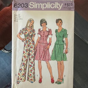 May include: Vintage Simplicity sewing pattern envelope featuring three fashion illustrations. The envelope displays the number 6203 and the price $1.25. The size is 12, with a bust of 34 inches and a waist of 26.5 inches.