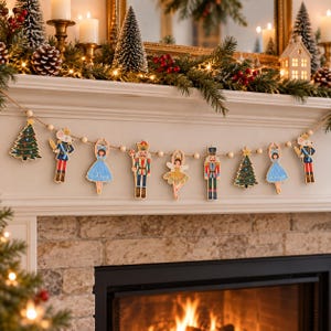 May include: A decorative garland featuring wooden cutouts of Christmas trees, nutcracker soldiers, ballerinas, and mice characters strung together with light-colored wooden beads on a natural twine cord for holiday seasonal display.