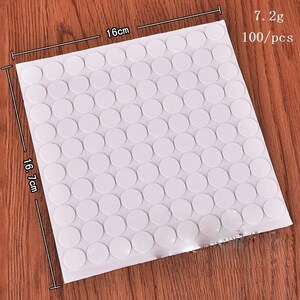 May include: A square sheet of 100 white circular adhesive stickers arranged in a grid. The sheet measures 16 cm by 16.7 cm, with a total weight of 7.2g. Each sticker is a solid white circle, presented as a set of 100 pieces on a single backing sheet.