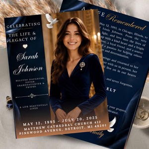 May include: A funeral program card featuring a portrait of a person in a navy blue velvet dress. The text reads Celebrating the Life & Legacy of Sarah Johnson, May 12, 1995 - July 20, 2025, and A Life Remembered, with white dove graphics on a dark blue background.