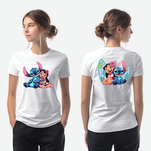 May include: A white short-sleeved t-shirt featuring a graphic print of the blue character Stitch and a girl with a pink flower in her hair. The front displays the pair sitting together, while the back shows them in front of a surfboard design.