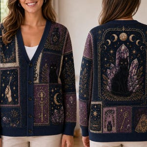 May include: A navy blue V-neck cardigan featuring a repeating pattern of mystical illustrations including a black cat, crystals, moon phases, keys, and candles. The design is displayed on both the front and back, with a button-down front closure.