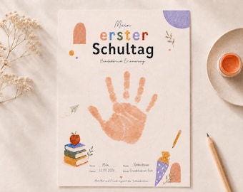 May include: A cream-colored paper print titled Mein erster Schultag Handabdruck Erinnerung featuring a central orange handprint, watercolor illustrations of books, an apple, a pencil, and a school cone, with blank lines for name, date, class, and school.