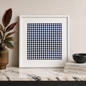Peut inclure: Une œuvre d'art murale carrée encadrée présentant un motif de grille répétitif composé de cercles bleu marine foncé sur un fond blanc. L'œuvre est insérée dans un cadre blanc simple, affichant un design géométrique occupant tout l'espace central.
