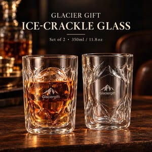 May include: A set of two clear ice-crackle glass tumblers with a 350ml / 11.8 oz capacity. Each glass features a textured geometric pattern and the Glaciergift logo with a mountain graphic. One glass contains an amber liquid and a round ice sphere.
