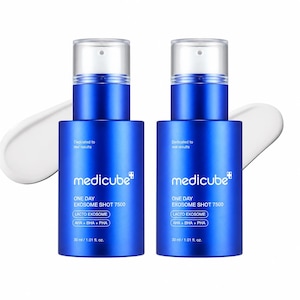 May include: Two identical blue cylindrical skincare bottles with clear pump caps. Each bottle features white text reading medicube, ONE DAY EXOSOME SHOT 7500, LACTO EXOME, AHA + BHA + PHA, and 30 ml / 1.01 fl. oz. A white cream smear is visible behind each bottle.