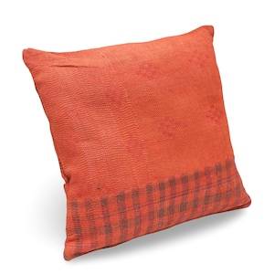 May include: A square throw pillow in a vibrant orange hue, featuring a textured surface with fine, dense stitching throughout. The lower section displays a contrasting dark grey and orange plaid pattern, adding a distinct visual border to the design.