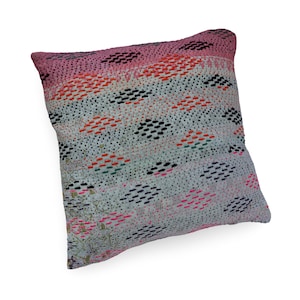 May include: A square throw pillow featuring a light-colored fabric base with an all-over pattern of small, hand-stitched horizontal dashes in black, orange, pink, and green. The top edge has a solid pink band, and the overall texture is quilted.
