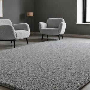 May include: A rectangular area rug with a thick, textured, grey shag pile surface. The rug features a dense, looped construction that creates a soft, uneven appearance across the entire top surface, providing a consistent grey colour throughout.