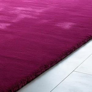 May include: A rectangular area rug in a deep magenta hue with a soft, plush, and dense pile texture. The rug features subtle variations in colour intensity across its surface, creating a soft, cloud-like visual effect throughout the fabric.