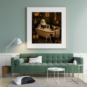 May include: A framed wall art print depicting a ghost sitting in a clawfoot bathtub filled with bubbles, reading a book. Three black and white cats are present in the bathroom setting, which is illuminated by several lit candles and warm light.