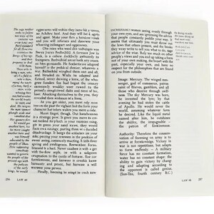 May include: An open book displaying pages 256 and 257, featuring black printed text on off-white paper. The left page is titled LAW 49, and the right page is titled LAW 48. The text includes paragraphs discussing historical and philosophical concepts.