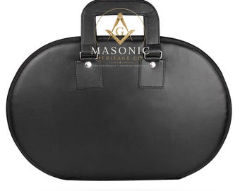 Può includere: Una valigetta da trasporto ovale nera con manico superiore e rivetti in metallo color argento. Il centro presenta un emblema massonico dorato a forma di squadra e compasso sopra il testo MASONIC HERITAGE CO. CRAFTED REGALIA HONORING TRADITION.