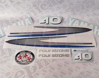 May include: A set of Yamaha outboard motor decals including two long grey and blue swooping graphics, two 40 number decals, two Yamaha text decals, two Four Stroke text decals, and one circular Ultra Low Emission badge with three red stars.