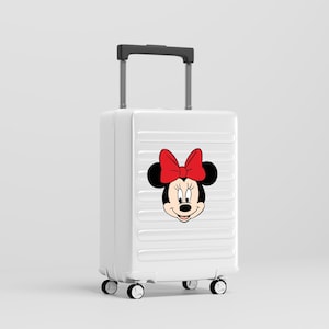 Może przedstawiać: Biała walizka na k&oacute;łkach z twardą skorupą, ozdobiona grafiką Myszki Minnie z przodu. Bagaż posiada wysuwaną czarną rączkę, cztery obrotowe k&oacute;łka oraz szereg poziomych, wyprofilowanych żłobień na zewnętrznej powierzchni obudowy.