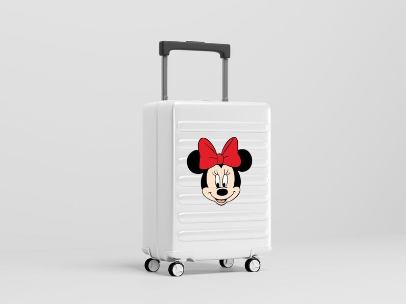 Może przedstawiać: Biała walizka na k&oacute;łkach z twardą skorupą, ozdobiona grafiką Myszki Minnie z przodu. Bagaż posiada wysuwaną czarną rączkę, cztery obrotowe k&oacute;łka oraz szereg poziomych, wyprofilowanych żłobień na zewnętrznej powierzchni obudowy.