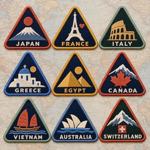 May include: A set of nine triangular embroidered patches featuring iconic landmarks and symbols for Japan, France, Italy, Greece, Egypt, Canada, Vietnam, Australia, and Switzerland, each with its respective country name stitched in white or yellow text.