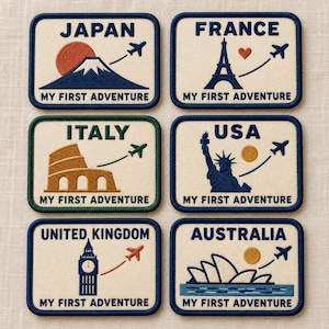 May include: A set of six rectangular embroidered patches featuring travel themes. Each patch displays a country name, a landmark, an airplane, and the text 'MY FIRST ADVENTURE'. Landmarks include Mount Fuji, the Eiffel Tower, the Colosseum, the Statue of Liberty, Big Ben, and the Sydney Opera House.