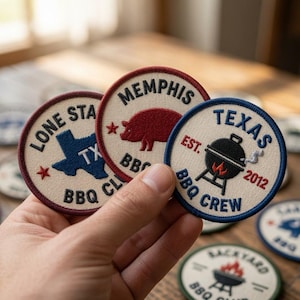 May include: Three circular embroidered patches with off-white backgrounds. One features a blue Texas map and 'LONE STAR BBQ CLUB', another a red pig and 'MEMPHIS BBQ', and the third a black grill with 'TEXAS BBQ CREW EST. 2012' in blue text.