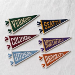 Può includere: Sei gagliardetti triangolari in feltro con testo ricamato. I gagliardetti sono verde con testo bianco VERMONT, blu navy con testo giallo SEATTLE, bordeaux con testo bianco COLUMBIA, viola con testo giallo NORTHFIELD, azzurro con testo bianco HUDSON e arancione con testo bianco BROOKLYN.