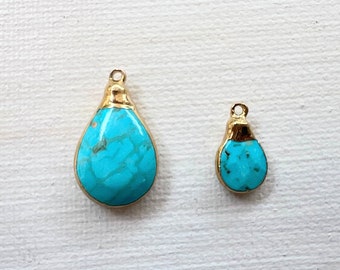 May include: Two turquoise teardrop-shaped pendants with gold settings. The larger pendant is about 1 inch long and the smaller pendant is about 1/2 inch long.